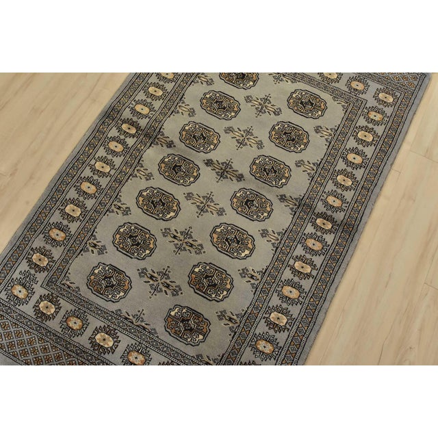 A tribal Bokhara rug hand-knotted with fine wool on a cotton foundation. This rug features rows of repeating medallions...