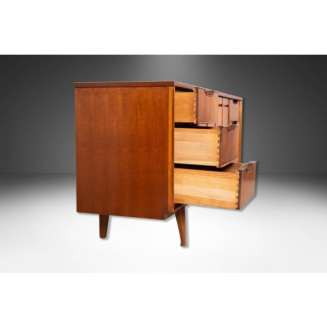 A classic Mid Century Modern walnut triple dresser or sideboard. This vintage walnut dresser features six dovetailed...