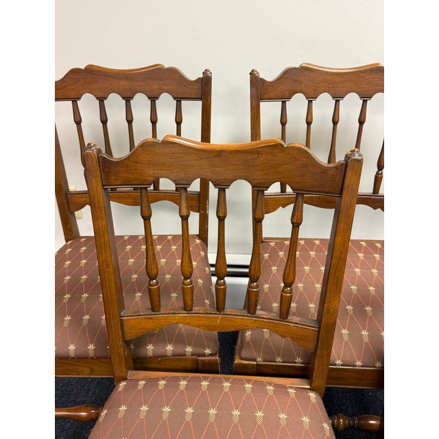 Beautiful set of six vintage dining chairs featuring warm, richly toned cherrywood frames, elegant turned spindle backs,...