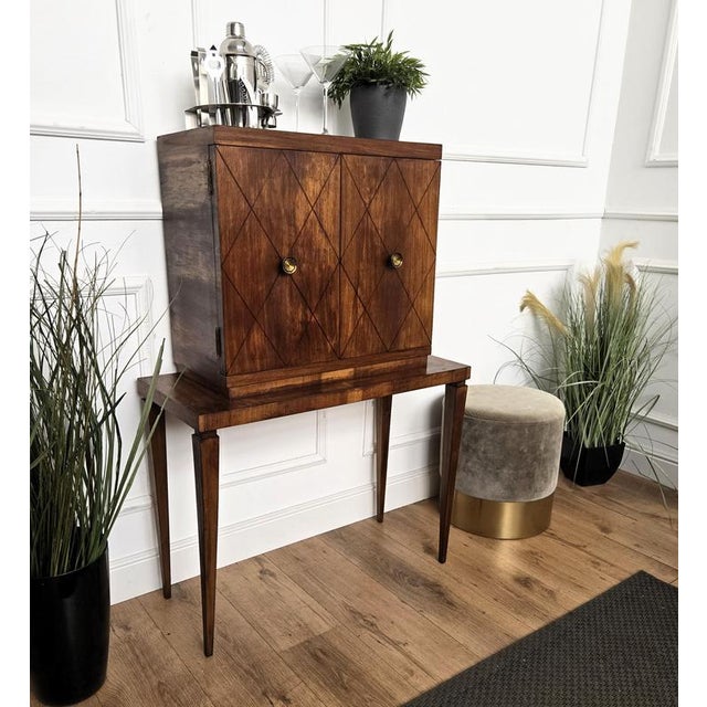 Beautiful 1950s Italian Art Deco bar cabinet in great wood veneer front double doors standing on four tapered legs giving...
