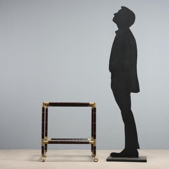 Italian-made stained bamboo bar cart from the 1950s and 1960s. The frame is embellished with brass fittings that lend a...
