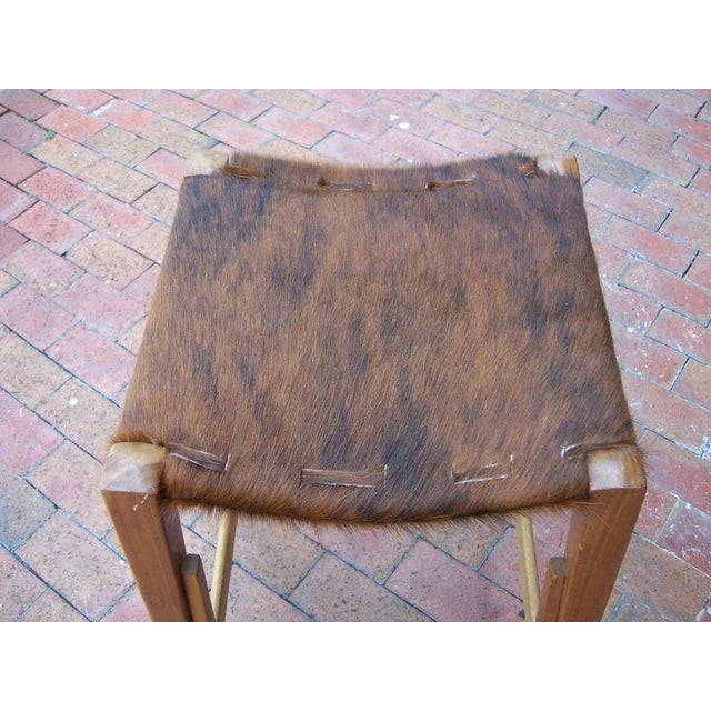 Extremely well designed, these bar stools have a rustic cowhide seat and intricate details in the woodwork, see photos.