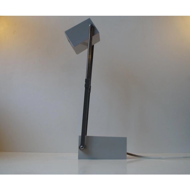 Small rectangular Grey plastic adjustable Table Lamp with an upper part that stretches & tilts. Manufactured by Louis...