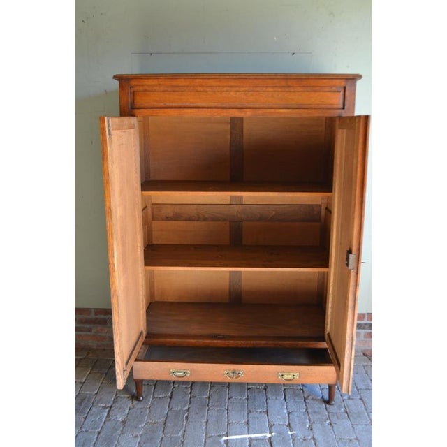 of a 19th-century Dutch oak maid's cupboard. The height is 171 cm. The width is 115 cm. The depth is 52 cm. A drawer at...