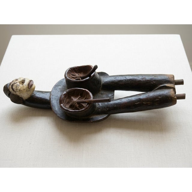 Gabonese 20th c. blacksmiths bellows hand crafted by the Mbaka people, depicting an anthropomorphic figure with a white...