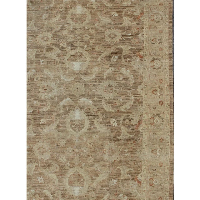 Variegated light brown, light green and earth tone Afghan made Sultanabad design rug with florals. rug, country of origin...