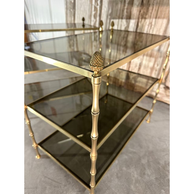 Pair of bronze side tables attributed to maison baguès, circa 1950-70. Bamboo-effect uprights and three smoked glass...