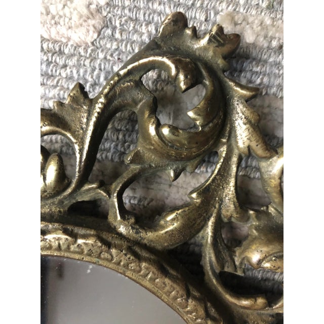 A heavy cast brass rococo style table top mirror, probably dating from 1870-80, the oval center surrounded by pierced...