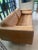 Handsome contemporary sofa upholstered in warm saddle-colored aniline leather, combining clean architectural lines with...