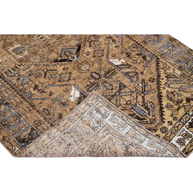 Beautiful vintage Persian distressed hand-knotted wool rug with a brown color field. This piece has a navy blue frame and...