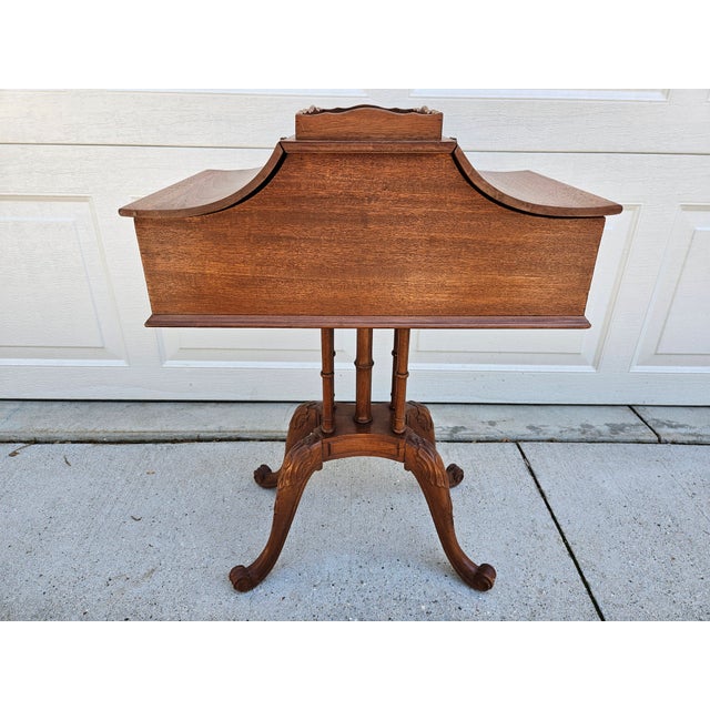 A unique mahogany side table having a central tabletop with tray lip and two flip top panels to access interior storage....