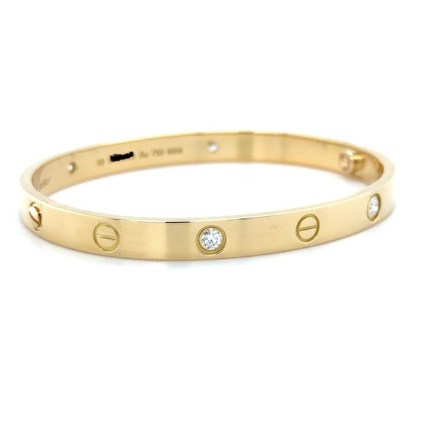 This classic bracelet by Cartier in their iconic LOVE Collection contains four round brilliant cut diamonds weighing 0.42...