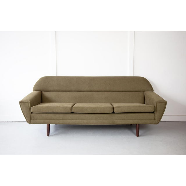 A striking Danish sofa, designed in a style similar to that of iconic Danish designer Kurt Østervig. with tapering...