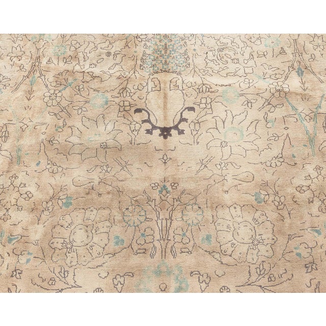 An early 20th century Persian Tabriz carpet, the camel field with a trellis drawn in brown of palmettes and flowering...