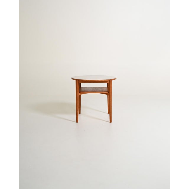 Round oak coffee table with a light-colored laminate top and a lower shelf. Swedish-made Ferdinand Lundqvist, 1950s-1960s....