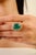 This luxury ring features a large, oval-cut emerald as the center stone, estimated to weigh 9.17 carats, surrounded by a...