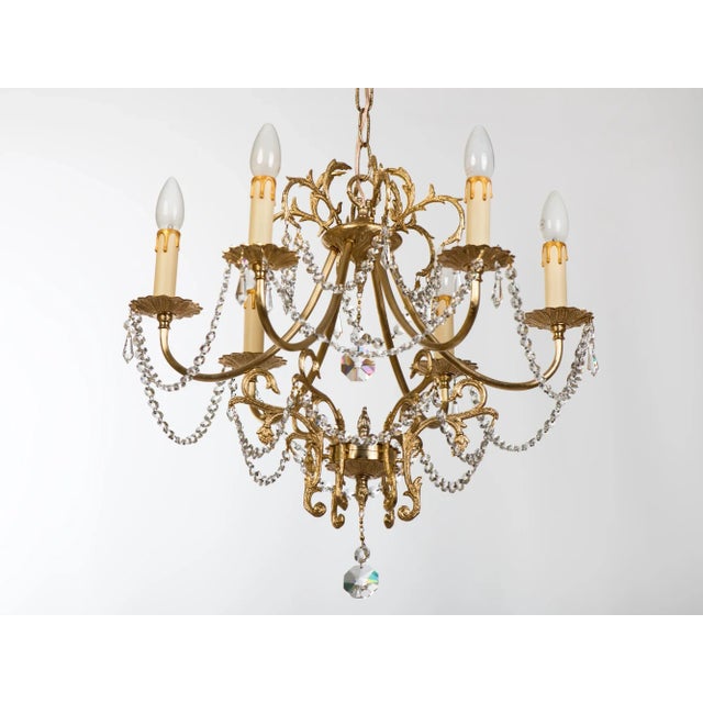 Spectacular 1970s Spanish Hollywood Regency 6-Light Brass Chandelier with Fine Crystal Drops. Masterfully handcrafted in...