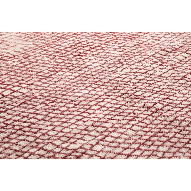 A dense, all-over lattice weave in crimson red catches the light in shifting waves, its texture reading almost like woven...