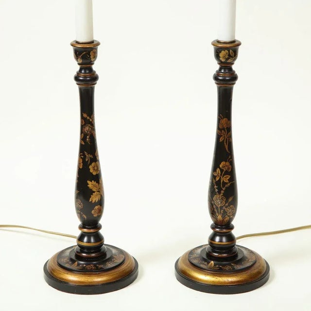 Each wooden base of baluster form; decorated in gold with floral and foliate sprays.