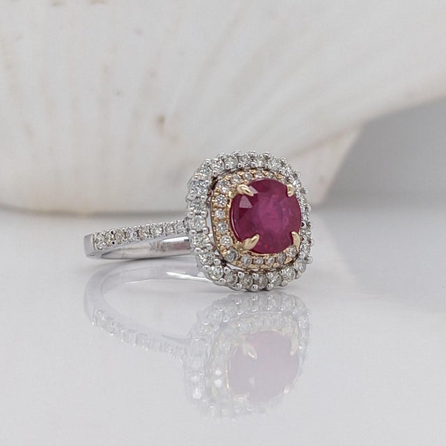 This 14K gold vintage inspired ring features a round ruby framed by a cushion double halo with a pave diamond studded...