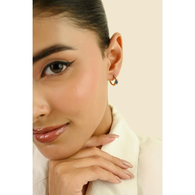 These elegant huggie hoop earrings feature 2 pear cut blue sapphire totaling 0.82 carats set in 14k yellow gold. Each...