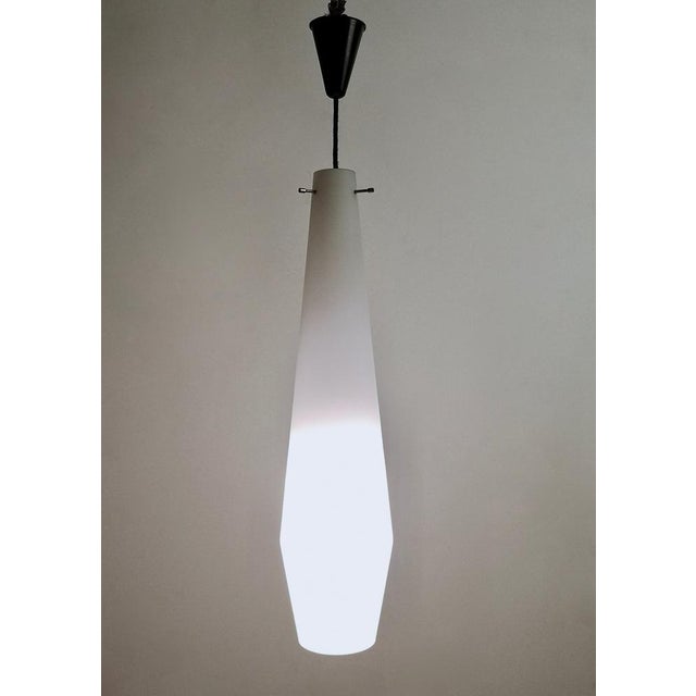 Made in Italy, 1950s. It is in encased glass and brass. This pendant is a vintage item, therefore it might show slight...