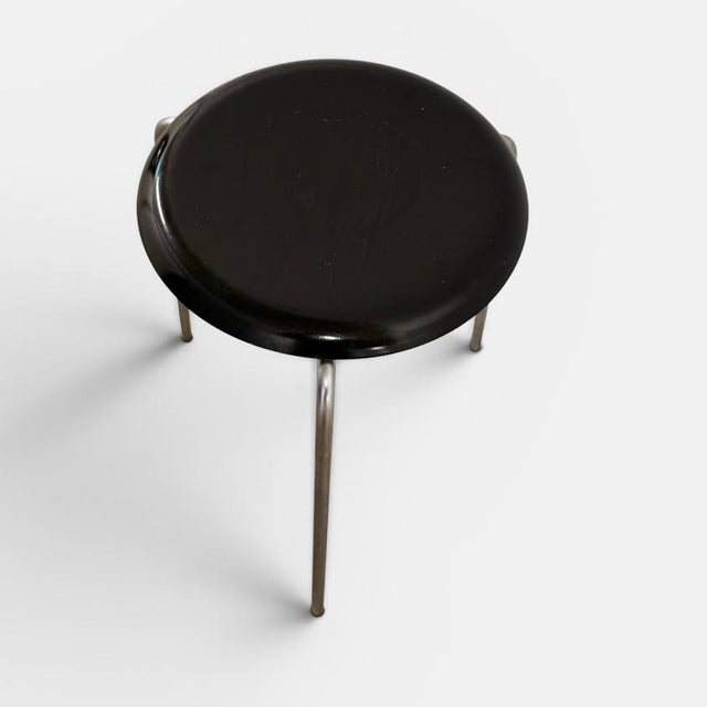 Early three-legged stool designed by arne jacobsen and produced by fritz hansen in denmark. executed with a black...