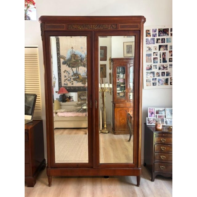 This Antique French Empire Mahogany Mirrored Armoire is a stunning piece of furniture that exudes elegance and...