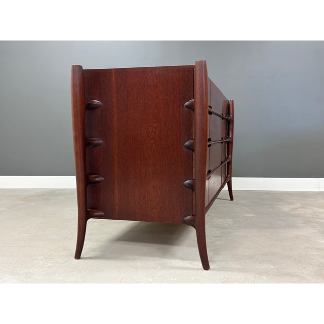 A mid century modern large teak twelve drawer dresser with sculpted pulls and beautifully crafted exoskeleton legs in the...