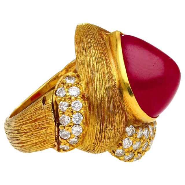 This 18K Yellow Gold ring features a 13.86 Carat cabochon pear cut Ruby and 1.75 Carats of round brilliant diamonds. The...