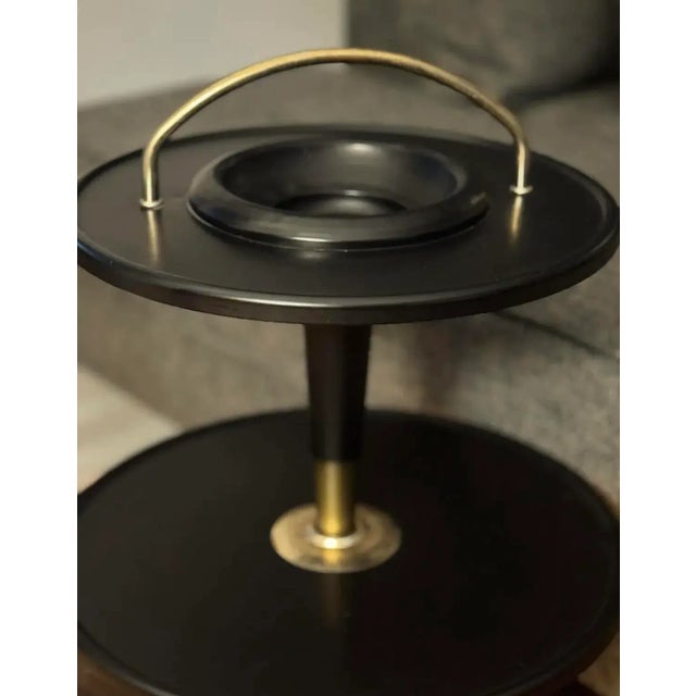 A sophisticated mid-century Italian two-tier side table, crafted in the 1950s and defined by its sleek black lacquered...