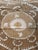 Hand-embroidered Suzani panel from Uzbekistan — a large tonal medallion in tan and ecru with curling leaf scrolls on an...