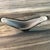 This sculptural piece features a dramatic boomerang winged form with bold black exterior and white interior casing encased...
