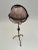 Tall freestanding globe on hand wrought iron stand with neutral colors.