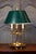 A French brass three-light bouillotte table lamp from the 19th century with green painted tôle shade, bird motifs and...