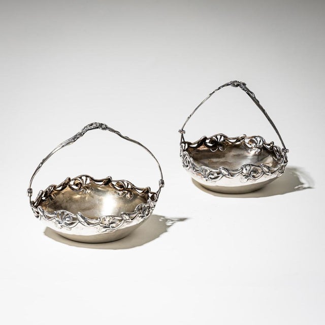Pair of elegant Art Nouveau silver bowls with handles and openwork rims adorned with stylized floral motifs. Both pieces...