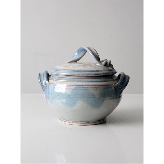 A vintage signed studio pottery lidded bowl finished in a soft blue-gray glaze. The rounded form and sculpted lid give it...