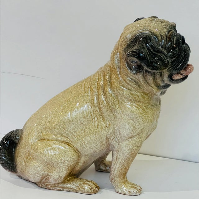 An Italian lifesize sculpture of a pug, produced circa 1960s, in glazed terracotta, painted with intricate mottled...
