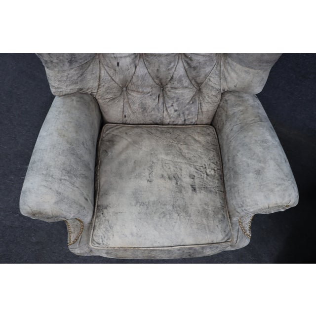 Pair of Leathercraft Inc. tufted leather recliner club chairs upholstered in distressed gray leather. Each chair features...