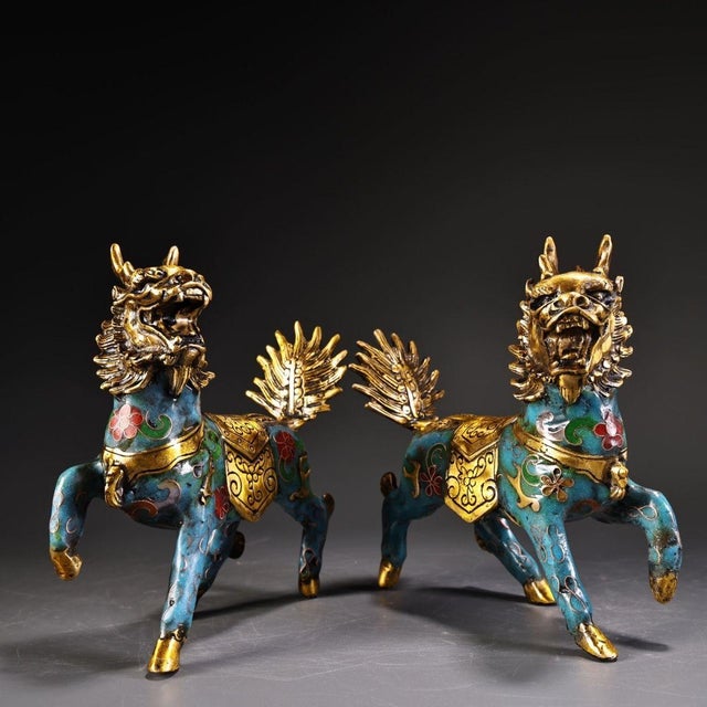This striking pair of gilt cloisonne enamel Qilin figures brings a bold, majestic presence to any interior. Qilin are...