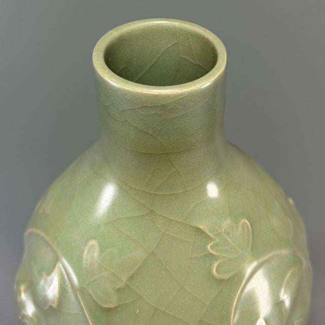 This antique Chinese Longquan celadon gourd vase is decorated with raised floral relief carving over the body. The elegant...