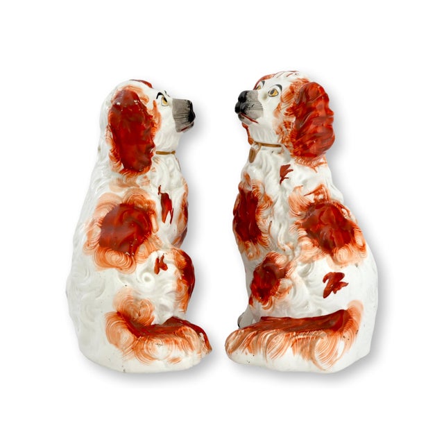Mid 19th century Staffordshire pottery King Charles spaniel dogs modeled in the traditional seated form with expressive...