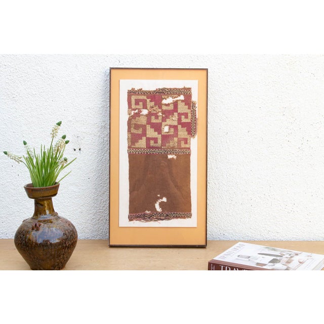 A captivating archaeological fragment showcasing ancient Andean step-fret geometry and rich native dye heritage. This...
