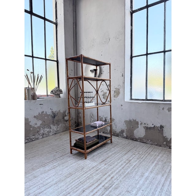 Vintage 1960s rattan shelf with solid black glass shelves. beautiful design and timeless style. it can be placed against a...