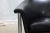 A pair of Norwegian tub chairs by Arne Halvorsen, produced by Sørli Møbler. Deeply curved black leather shells that wrap...