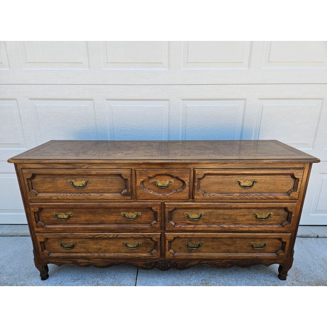 French style Baker Furniture seven drawer double dresser with a banded burlwood veneer top. The dresser is in very good...