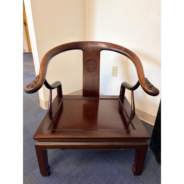 Pair of vintage Chinese horseshoe armchairs. Solid hardwood construction, made in Hong Kong, with carved longevity symbols...