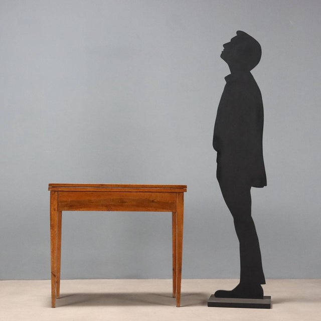 Directoire walnut game table. Revolving top concealing an open compartment underneath, book-style opening. Rosewood,...