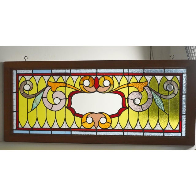 Victorian style stained glass window with clear beveled glass rondels against a classic yellow teardrop background....