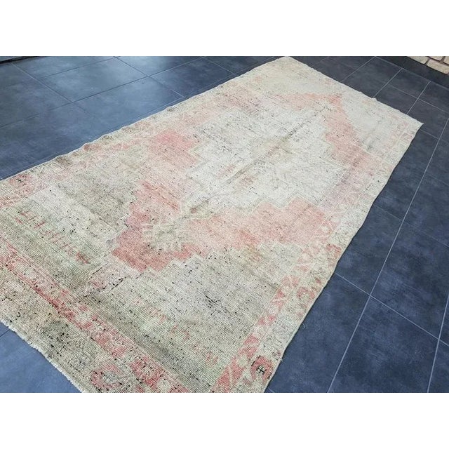 This is a vintage Turkish Oushak rug from the 1960s. The piece was hand-knotted.